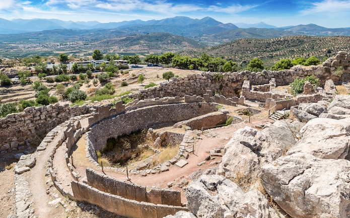 Ancient ruins of Mycenae with mountainous landscape in Greece.