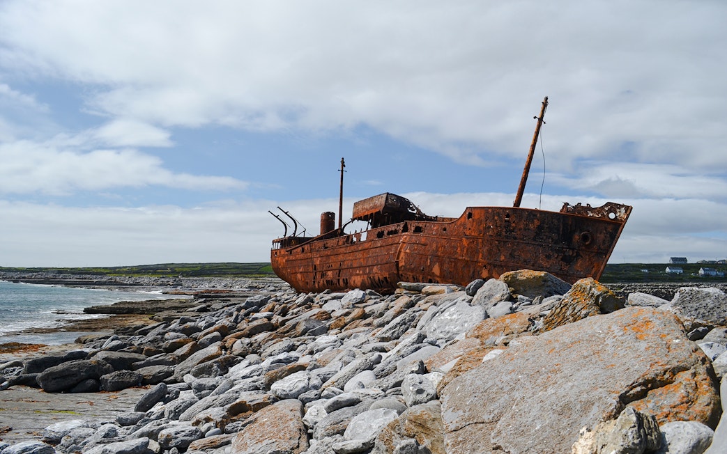 Rusty MV Plassy shipwreck on rocky shore, Inisheer Island, Ireland.