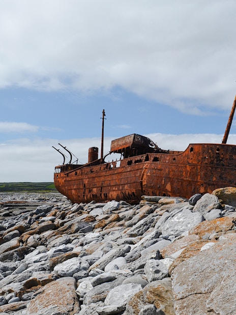 Rusty MV Plassy shipwreck on rocky shore, Inisheer Island, Ireland.