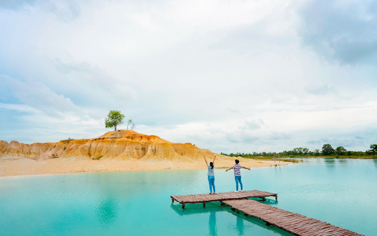 Couple on pier overlooking Blue Lake, Bintan Mini Desert in the background.