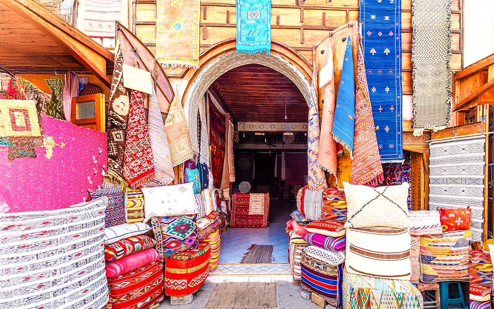 Colorful textiles and rugs displayed at a shop in the Medina Souks, Marrakesh.