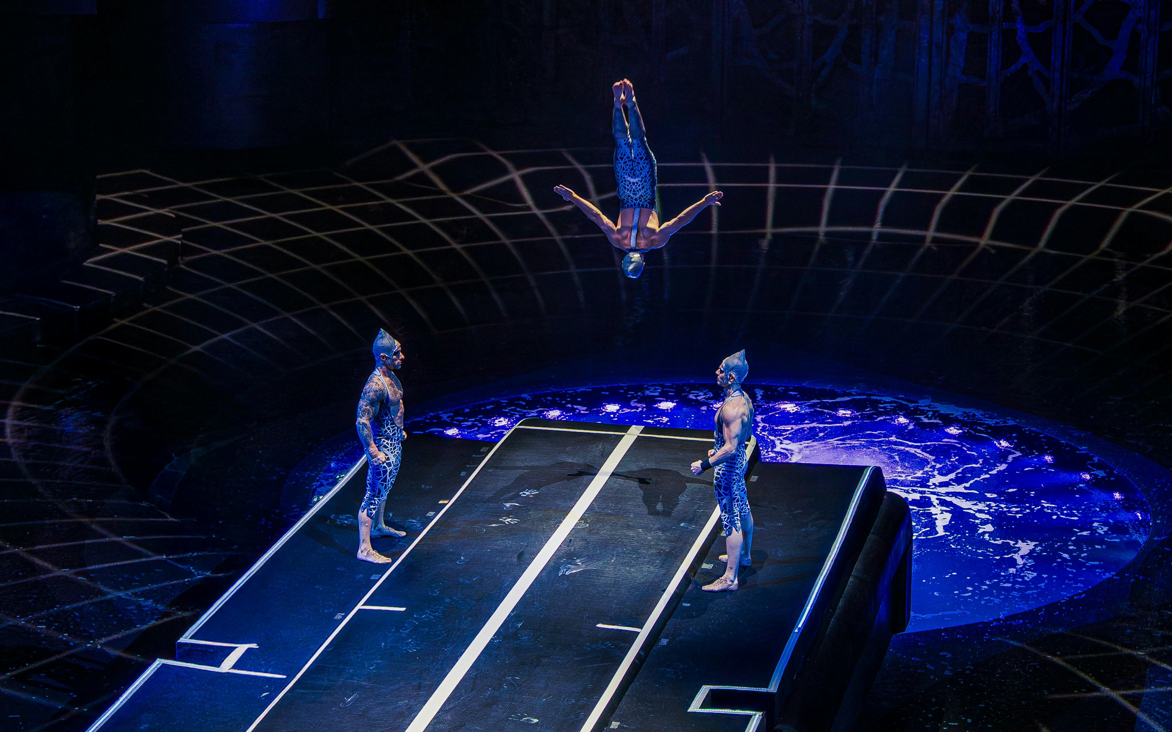 Acrobat flipping mid-air during La Perle performance at Tower Bridge.