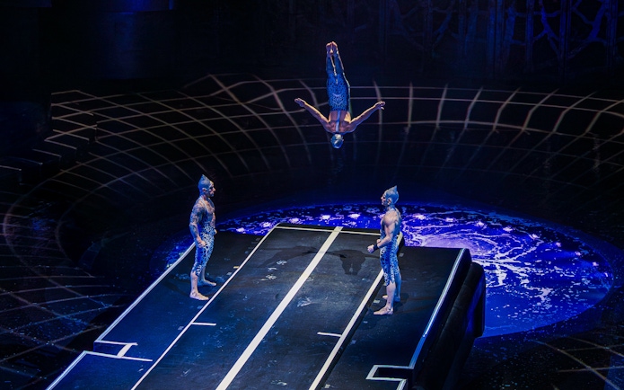 Acrobat flipping mid-air during La Perle performance at Tower Bridge.