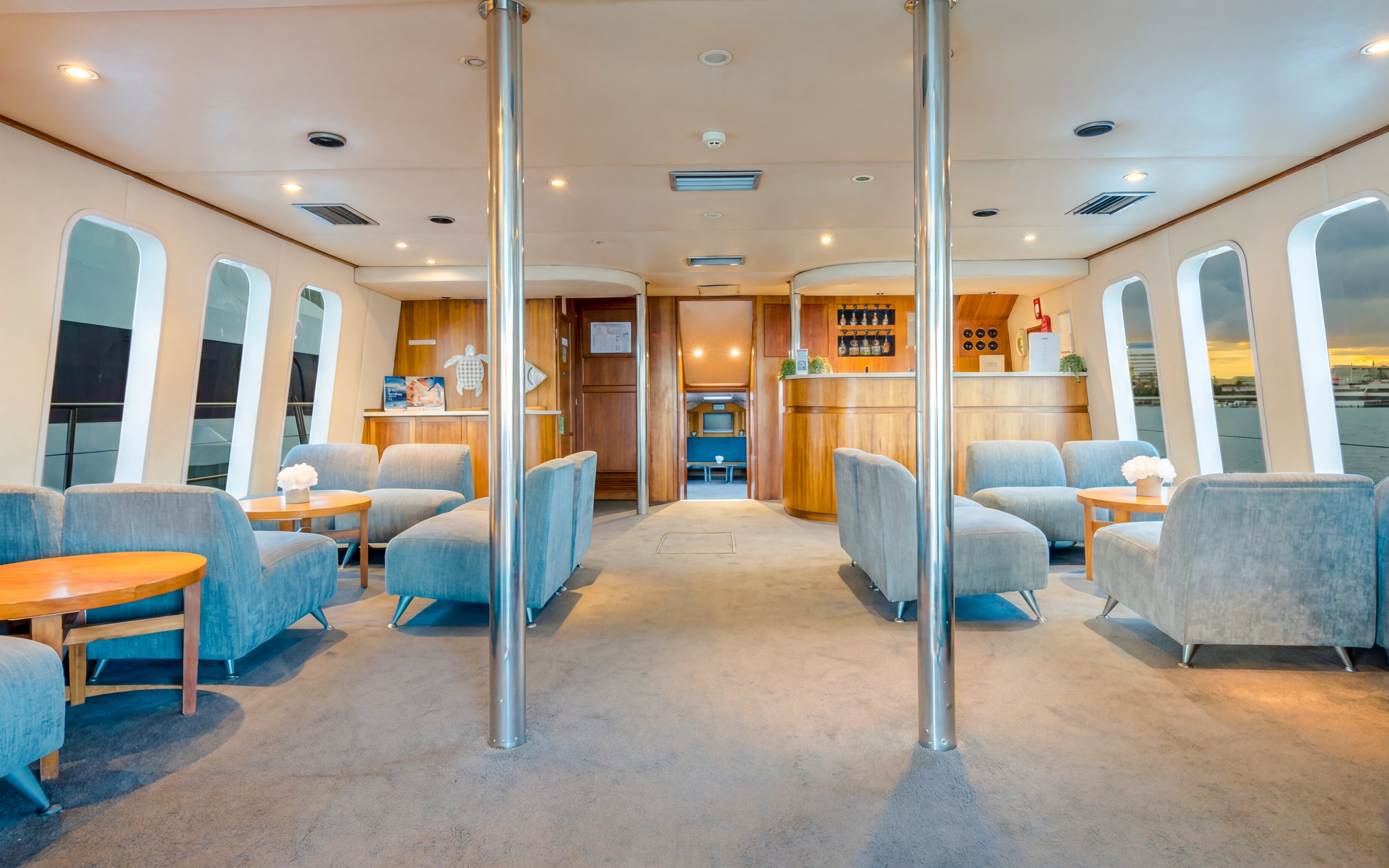 Interior of a luxury yacht lounge with seating and bar on Gold Coast whale watching tour.