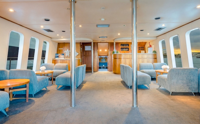 Interior of a luxury yacht lounge with seating and bar on Gold Coast whale watching tour.
