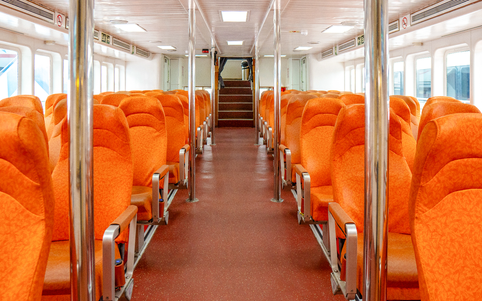 Ferry interior with orange seats on the Singapore to Batam route.