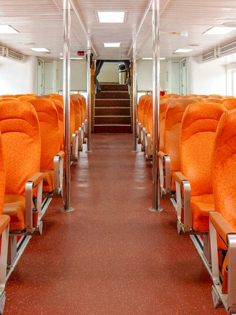 Ferry interior with orange seats on the Singapore to Batam route.