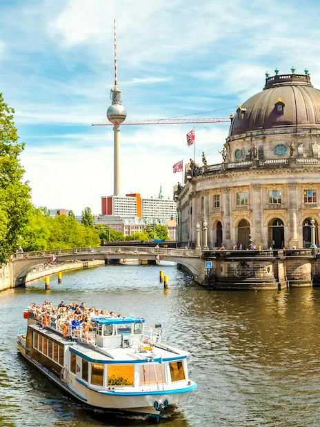 Boat on the Spree River near Berlin Cathedral and TV Tower during hop-on hop-off tour.