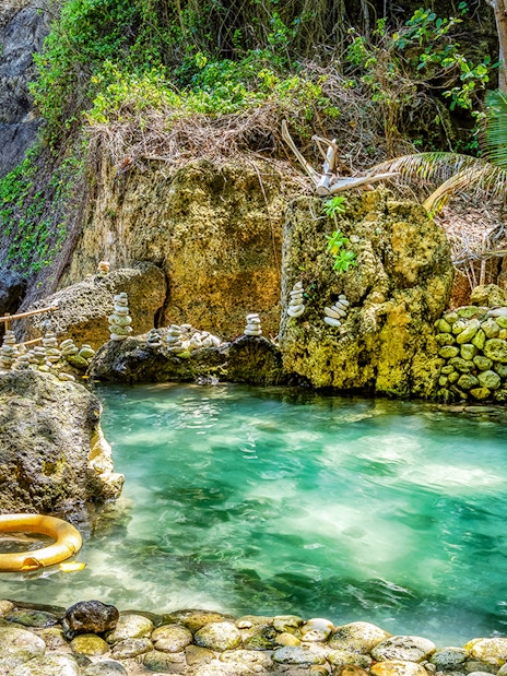Tembeling Beach cave pool with turquoise water and stone formations in Bali.
