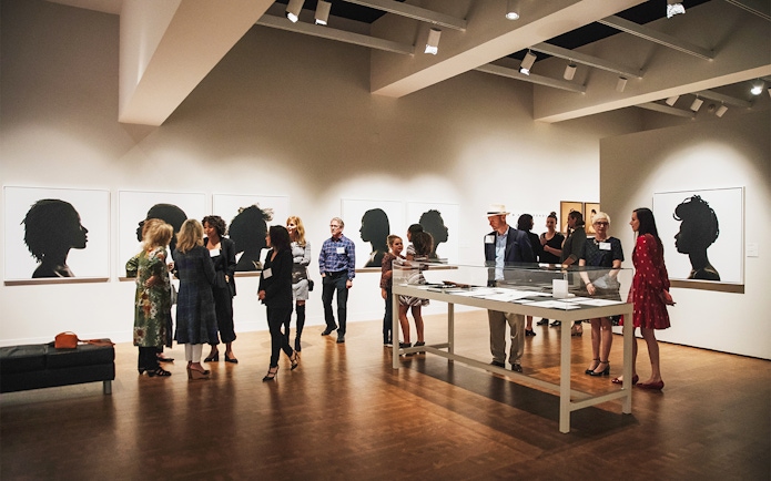 Art gallery visitors viewing silhouette portraits, San Diego All-Inclusive Pass.