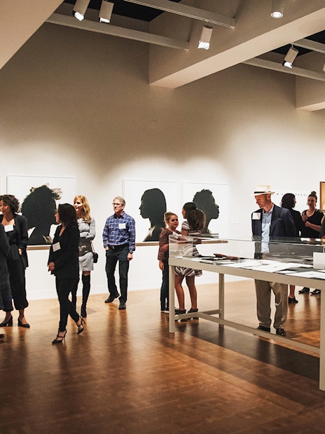 Art gallery visitors viewing silhouette portraits, San Diego All-Inclusive Pass.