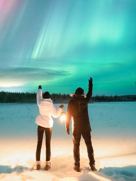 Couple watching Northern Lights in Levi, Finland.