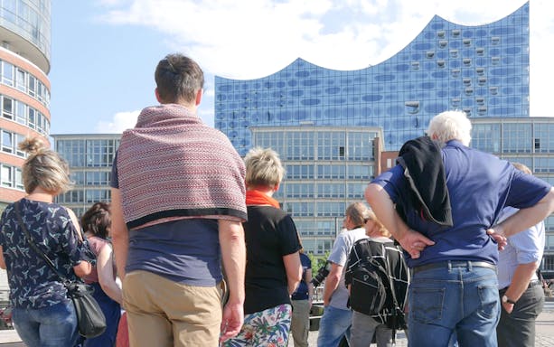 Group of tourists on a guided tour outside Elbphilharmonie, Hamburg.