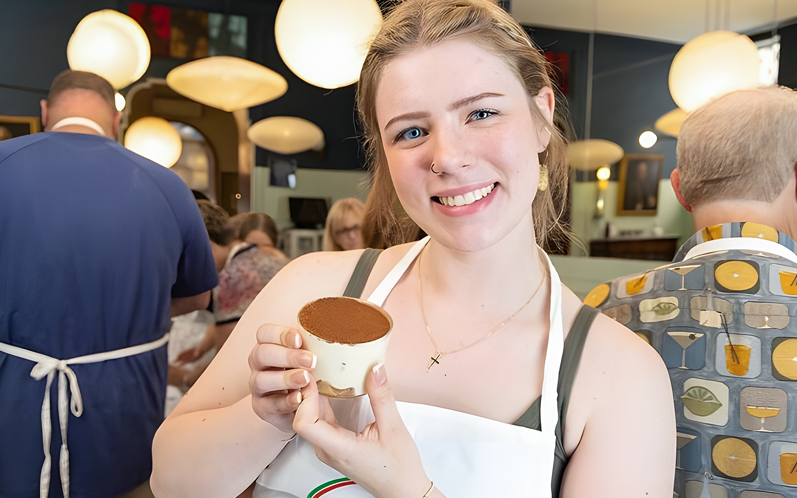 Cooking class participant holding tiramisù near Piazza Navona, Rome.