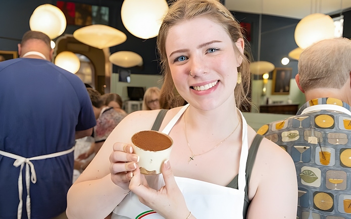 Cooking class participant holding tiramisù near Piazza Navona, Rome.