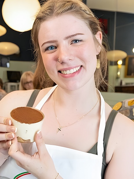 Cooking class participant holding tiramisù near Piazza Navona, Rome.