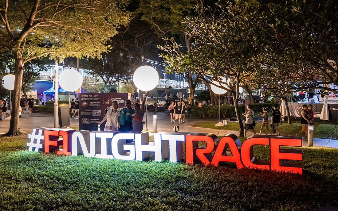 Women posing at an F1 Singapore sign.