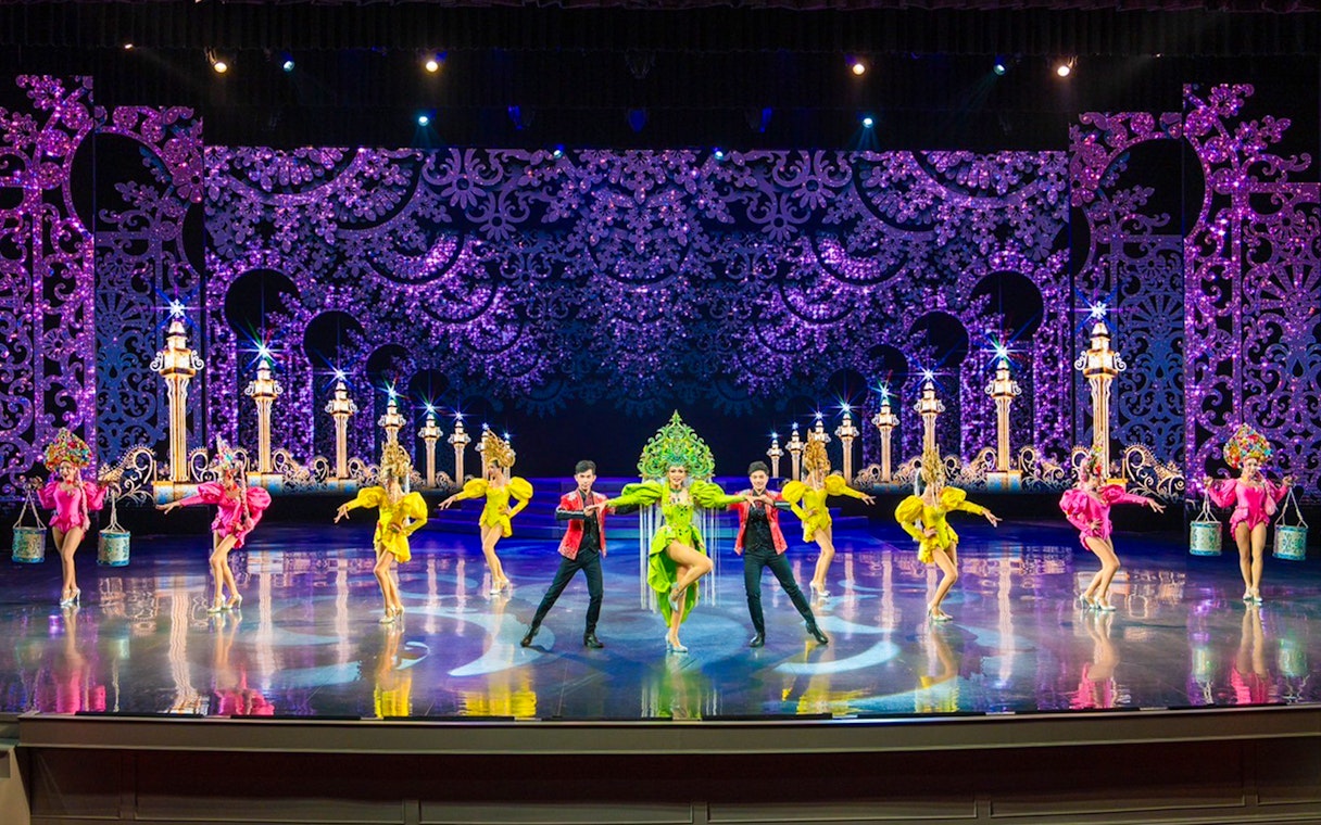 Performers in colorful costumes on stage at The Colosseum Show.