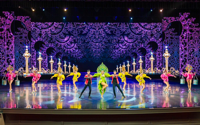 Performers in colorful costumes on stage at The Colosseum Show.