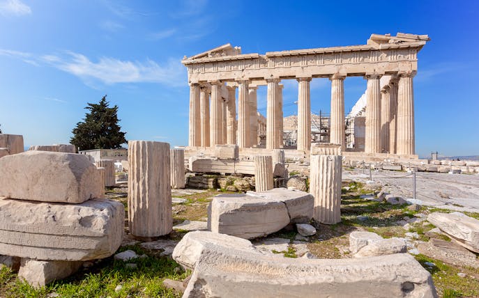 Parthenon temple ruins on the Acropolis in Athens, Greece, with scattered ancient columns.