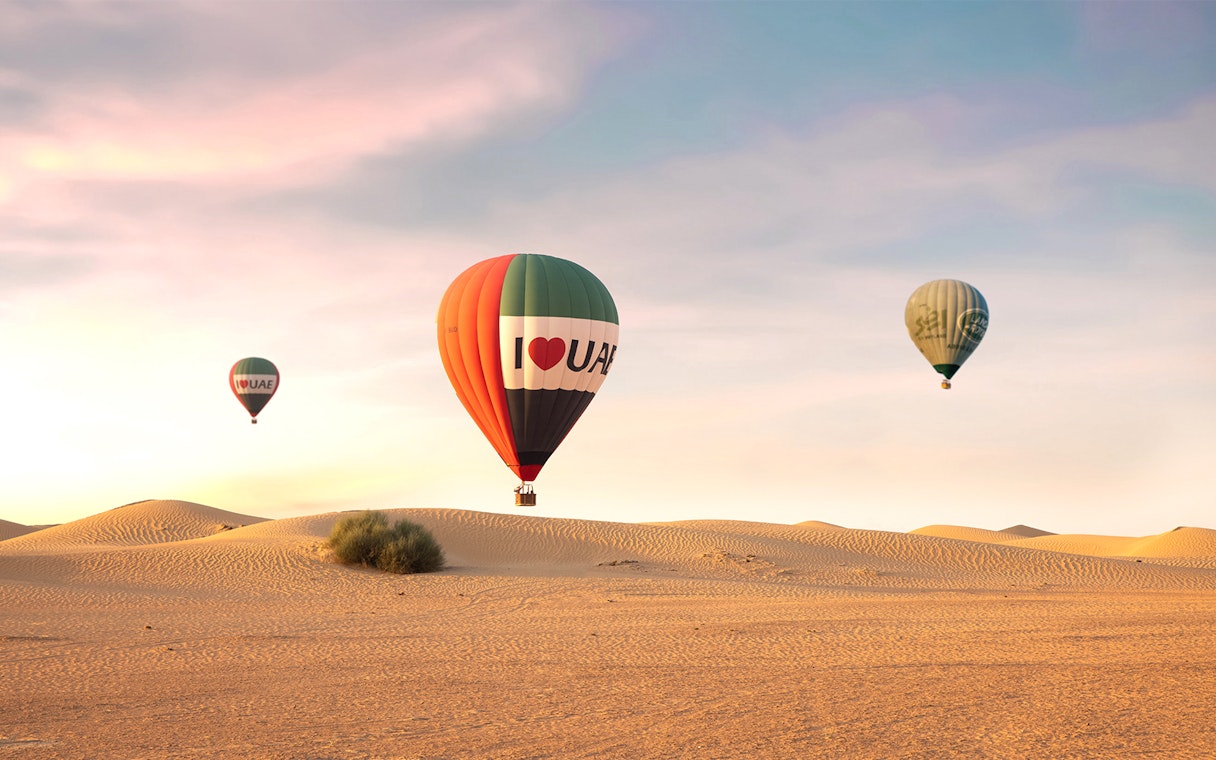 Hot air balloons over desert at sunrise, UAE premium experience.