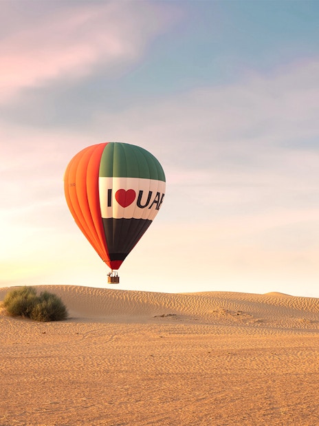 Hot air balloons over desert at sunrise, UAE premium experience.