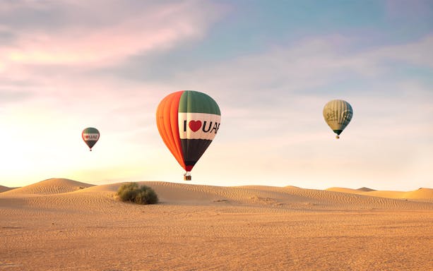 Hot air balloons over desert at sunrise, UAE premium experience.