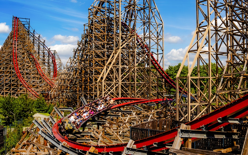 Rollercoaster at Energylandia Theme Park, Zator, Poland, with riders on a wooden track.
