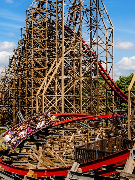 Rollercoaster at Energylandia Theme Park, Zator, Poland, with riders on a wooden track.