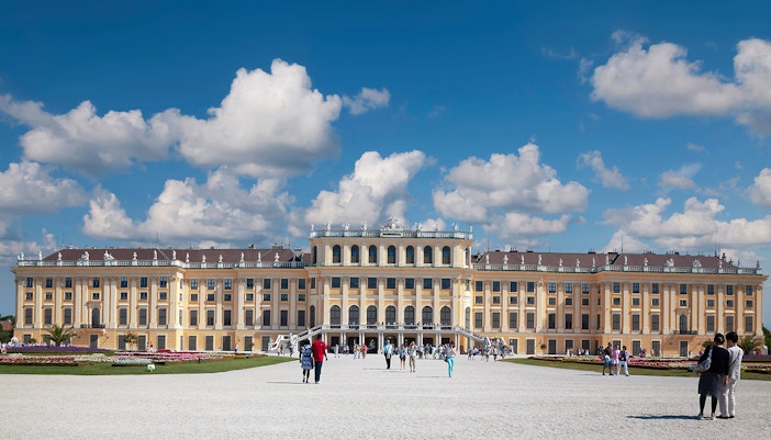 Schönbrunn Palace in Vienna with visitors walking in the foreground.