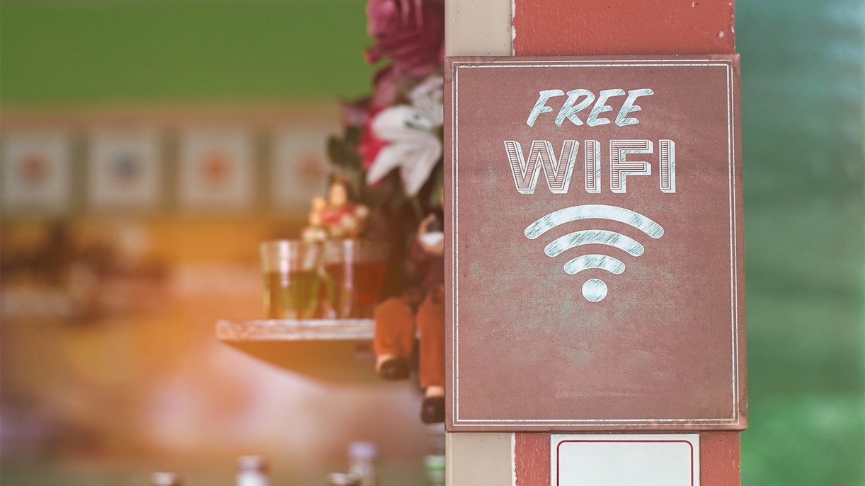 Free WiFi sign near Malaga Cathedral with drinks in the background.