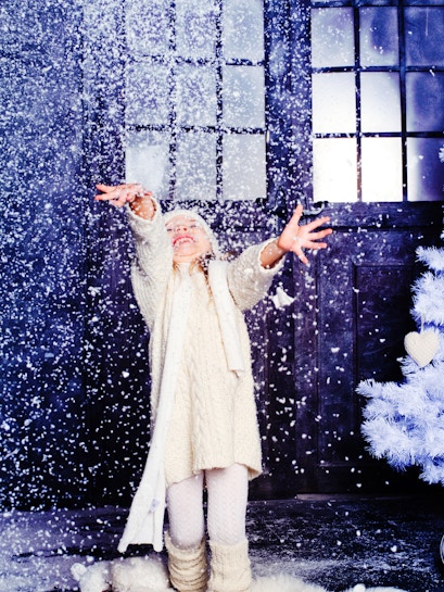 Child enjoying artificial snow at Snow Abu Dhabi indoor attraction.