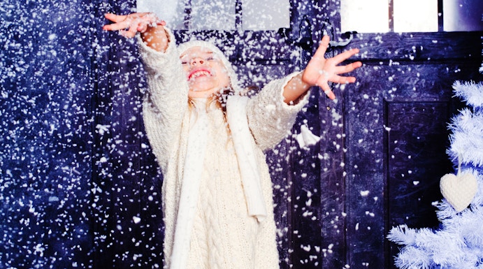 Child enjoying artificial snow at Snow Abu Dhabi indoor attraction.