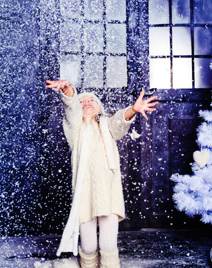 Child enjoying artificial snow at Snow Abu Dhabi indoor attraction.