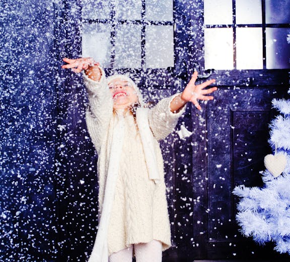Child enjoying artificial snow at Snow Abu Dhabi indoor attraction.