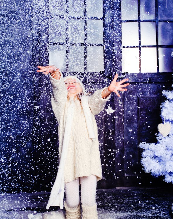 Child enjoying artificial snow at Snow Abu Dhabi indoor attraction.