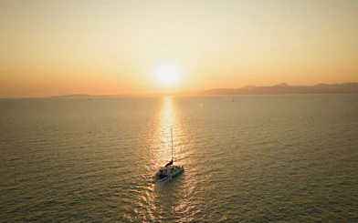 Boat sailing towards sunset in Mallorca.