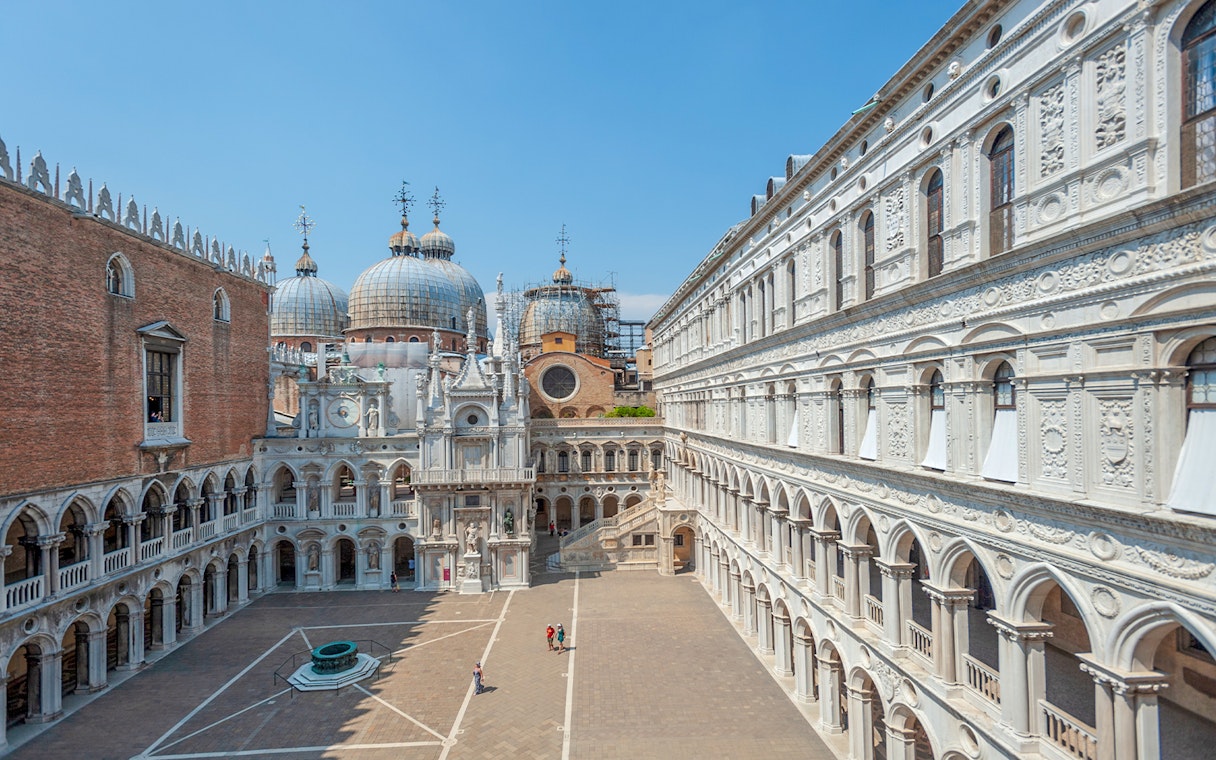 Doge's Palace courtyard with view of St. Mark's Basilica domes in Venice.
