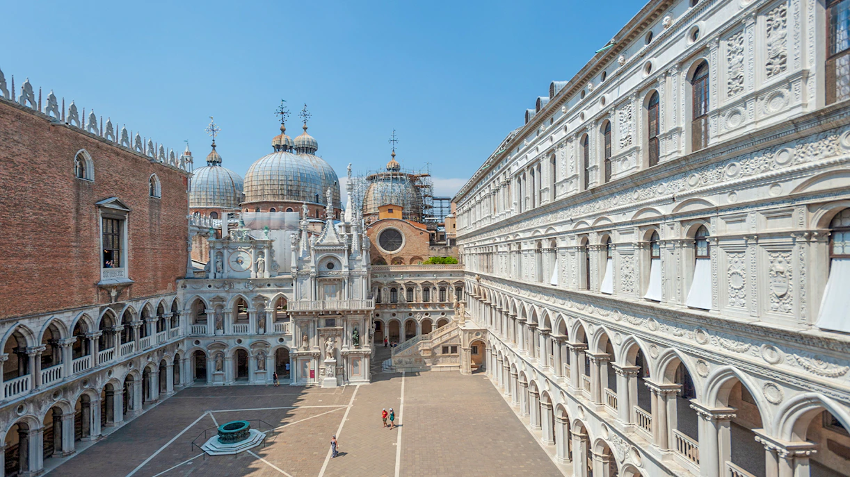 Doge's Palace courtyard with view of St. Mark's Basilica domes in Venice.