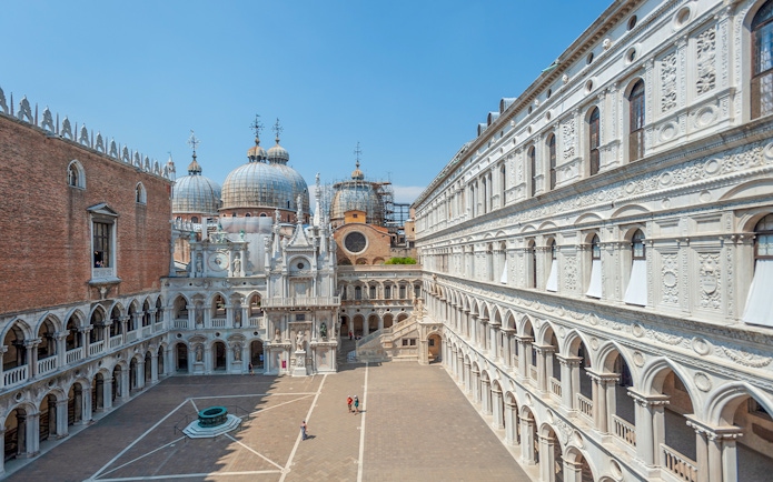 Doge's Palace courtyard with view of St. Mark's Basilica domes in Venice.