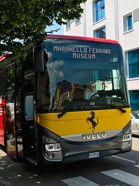 Bus transfer at Modena Ferrari Museum with people boarding.
