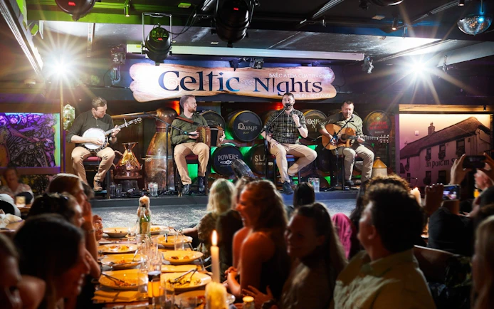 Musicians performing at Celtic Nights show in Dublin with audience dining.