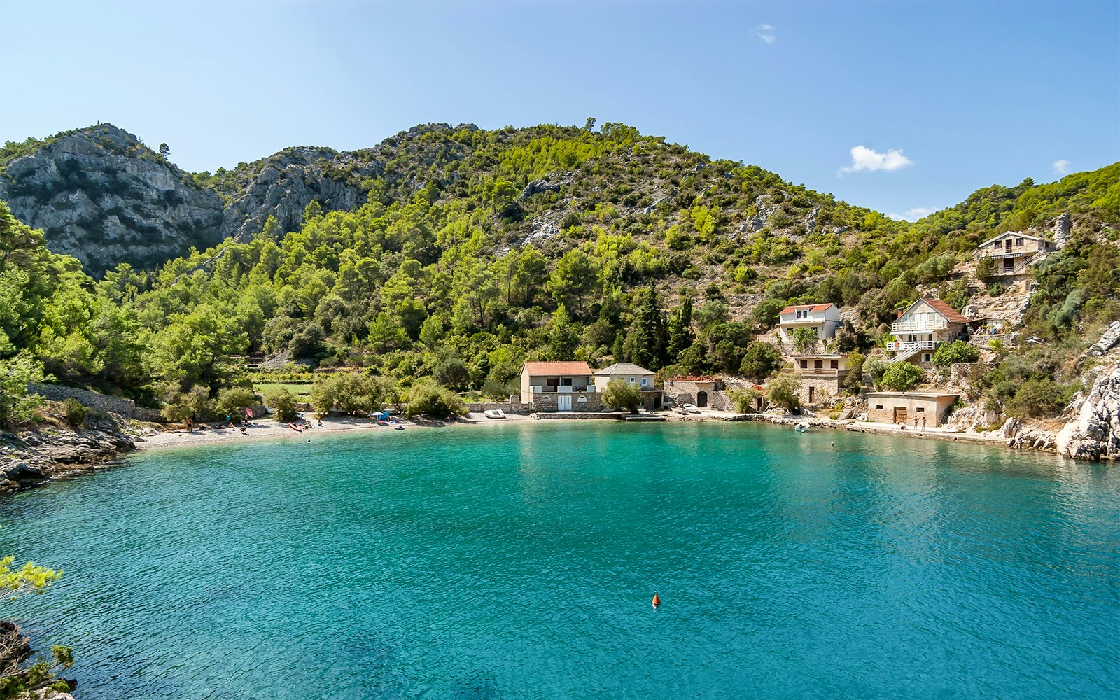 Stiniva beach with clear blue water and surrounding hills in Stiniva cove, Hvar Island, Croatia.