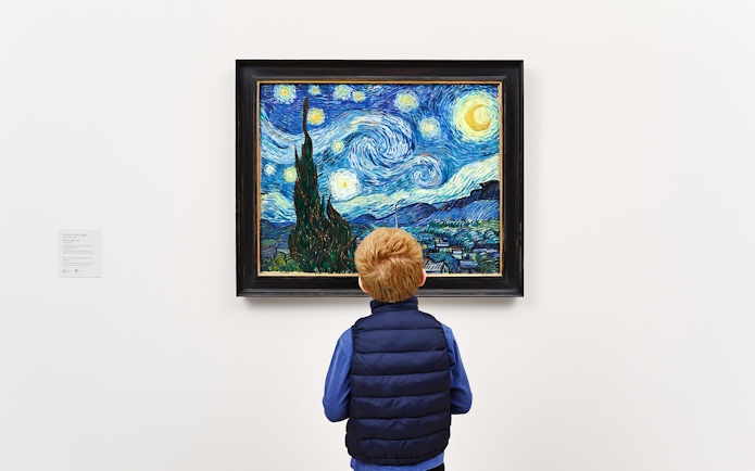 Child viewing Van Gogh's "Starry Night" painting in a museum.