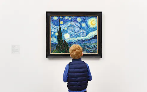 Child viewing Van Gogh's "Starry Night" painting in a museum.