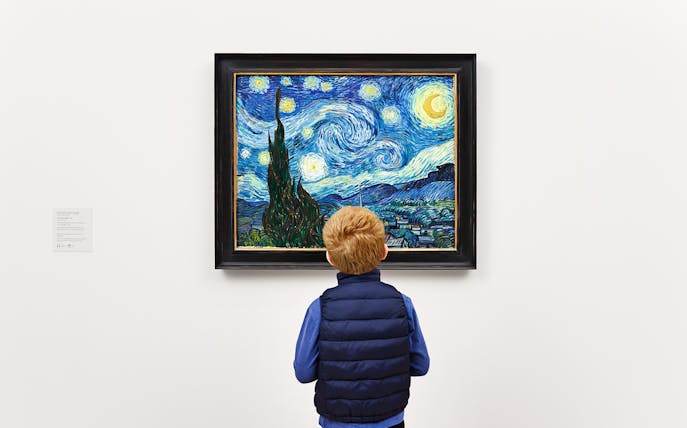 Child viewing Van Gogh's "Starry Night" painting in a museum.