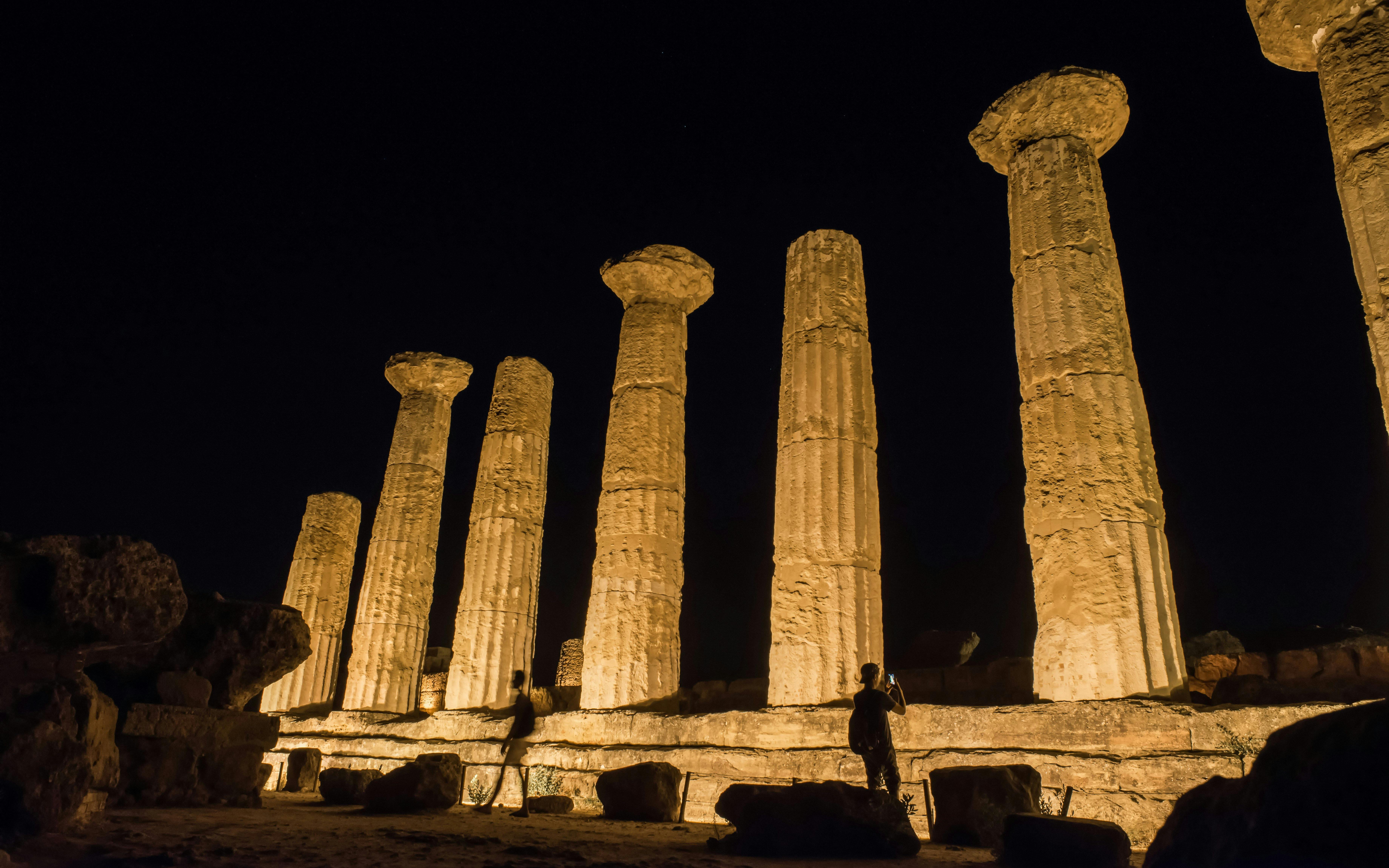 Ancient temple columns illuminated at night in Agrigento, Sicily, Italy.