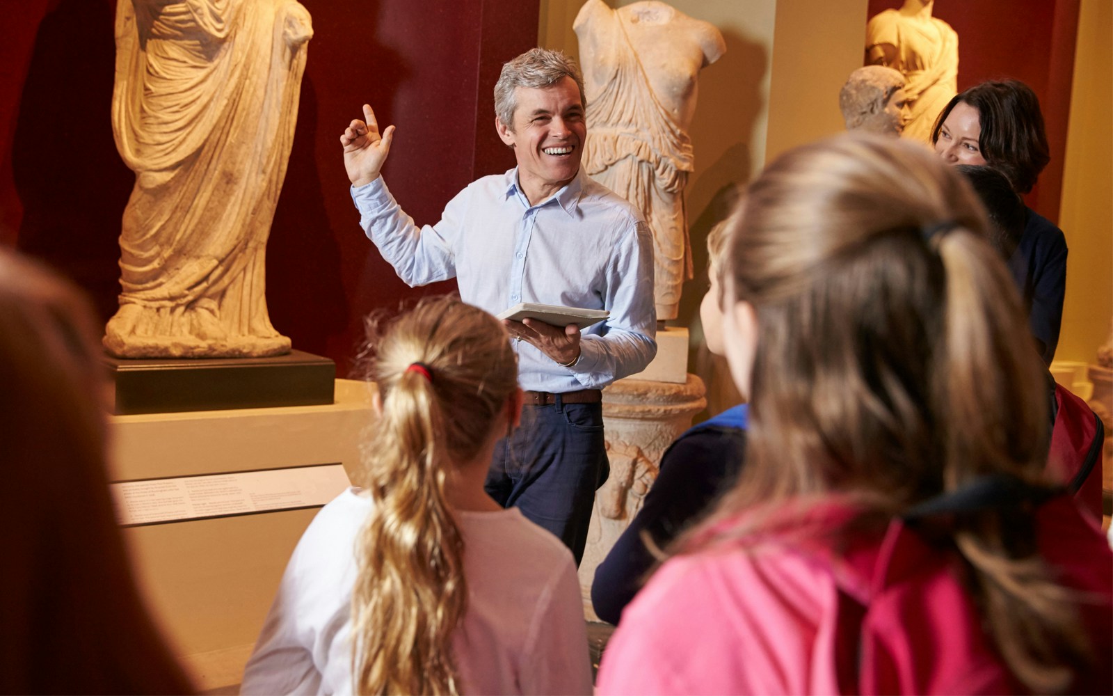 Tour guide explaining sculptures to visitors at Bargello Museum in Florence.