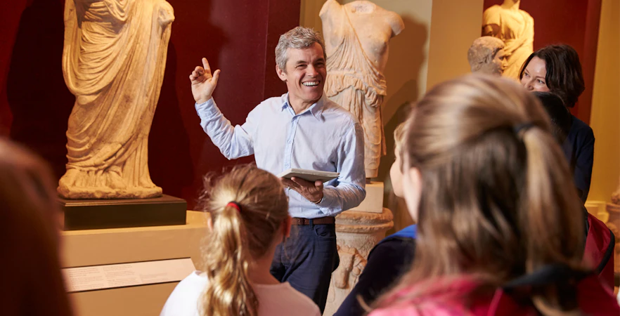 Tour guide explaining sculptures to visitors at Bargello Museum in Florence.