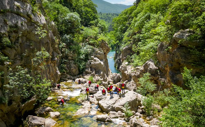 Canyoning group exploring rocky river gorge near Split.